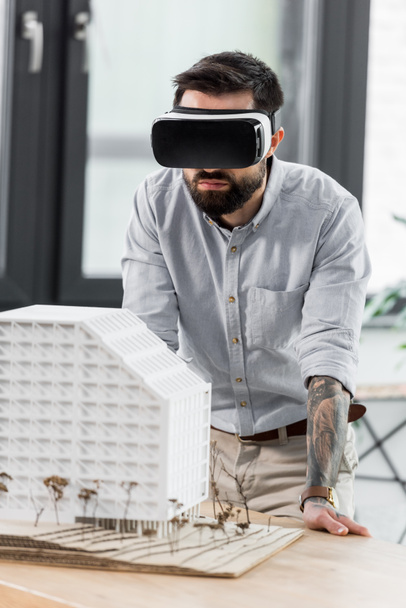 virtual reality architect in virtual reality headset looking at model of house  - 写真・画像