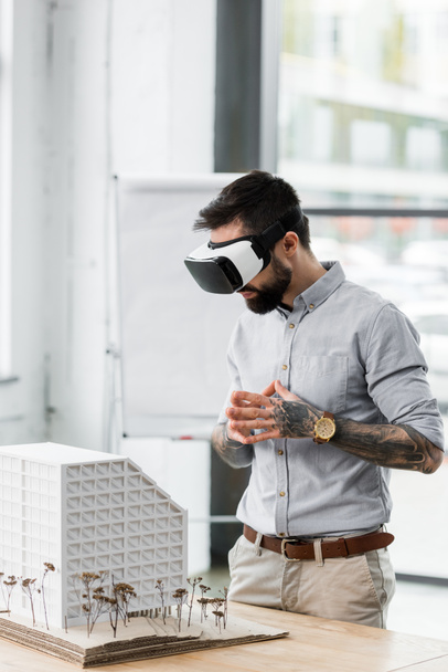 virtual reality architect in virtual reality headset looking at model of house  - Φωτογραφία, εικόνα