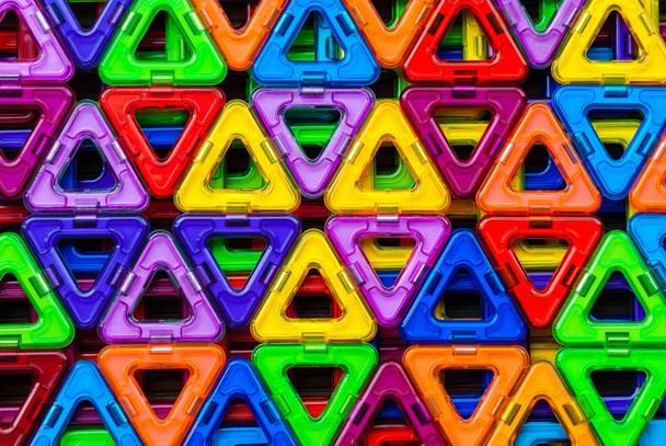 Tło z kolorowych trójkątów. Konstruktor magnetyczny. Wzór kolorowych trójkątów z tworzywa sztucznego - Zdjęcie, obraz