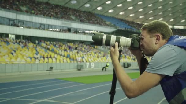 A photographer, photographers with a camera in a stadium during a football match. - Imágenes, Vídeo