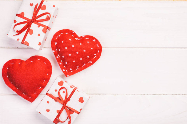 Sevgililer veya diğer tatil el yapımı mevcut kağıt ile tatil sarmalayıcı kırmızı kalpler ve hediye kutusunda. Tasarım için kopya alanı görünümüyle Beyaz ahşap masa üstü, boş alanı kutusu hediye sunmak - Fotoğraf, Görsel