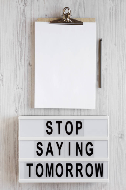 "Σταματήστε να λέτε αύριο" λέξεις σε ένα lightbox, πρόχειρο με κενό - Φωτογραφία, εικόνα