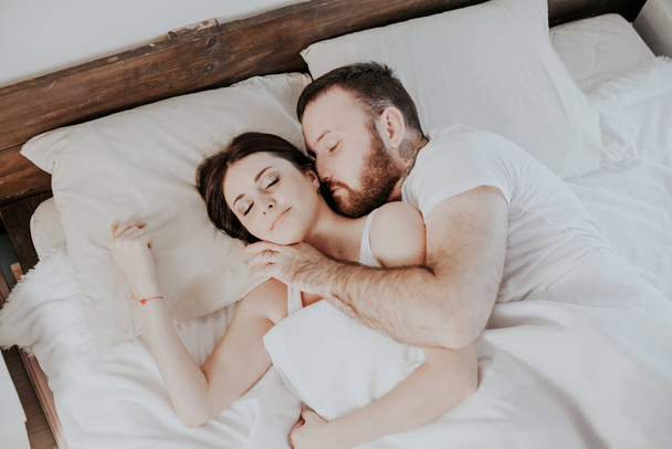 marido y mujer se despiertan por la mañana en el dormitorio del amor de fin de semana
 - Foto, Imagen
