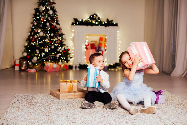 Menino e menina abrem presentes de Natal Ano Novo inverno árvore de Natal
 - Foto, Imagem