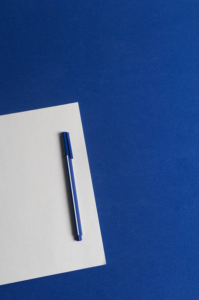 Mesa en azul clico con hoja de papel en blanco y lapicero en azul listo la metas del ao 2020 - 写真・画像