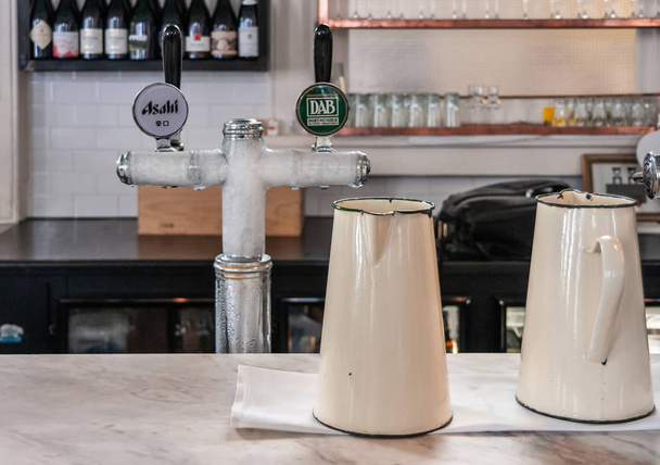 2 Kanister und ein eisgekühlter 2-Griff-Wasserhahn im europäischen Café in Melb - Foto, Bild