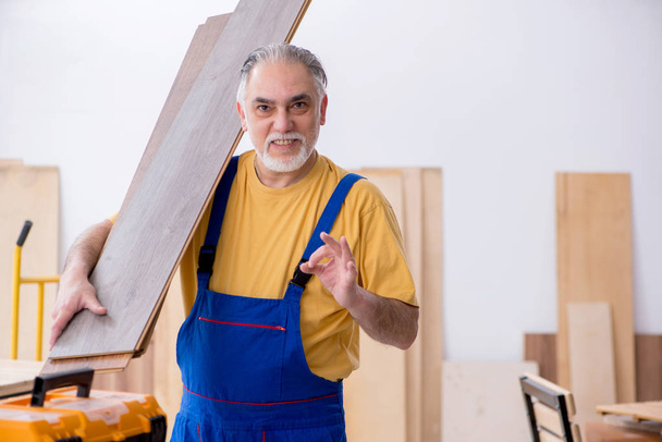 Παλαιός αρσενικός ξυλουργός που εργάζεται στο εργαστήριο - Φωτογραφία, εικόνα