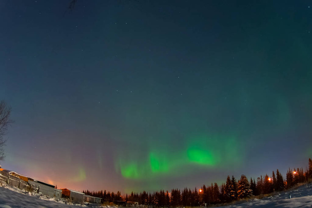 Aurora borealis στη νύχτα βόρειο ουρανό. Ιονισμός σωματιδίων αέρα στην ανώτερη ατμόσφαιρα. - Φωτογραφία, εικόνα
