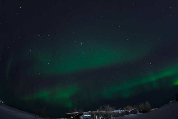 Aurora borealis in de nacht noordelijke hemel. Ionisatie van luchtdeeltjes in de bovenste atmosfeer. - Foto, afbeelding