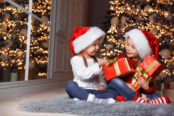 Cute little children with Christmas gifts at home - Foto, imagen