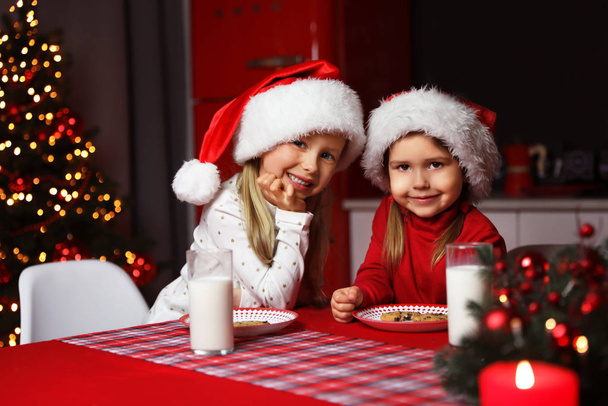 Χαριτωμένα παιδάκια στο τραπέζι στην τραπεζαρία. Χριστούγεννα - Φωτογραφία, εικόνα