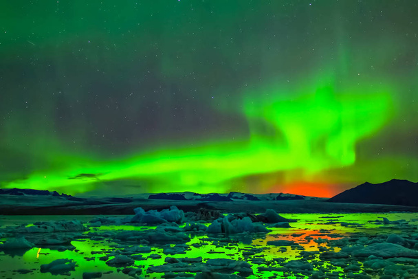 Aurora Borealis na nocnym niebie północnym. Jonizacja cząstek powietrza w górnej części atmosfery. - Zdjęcie, obraz