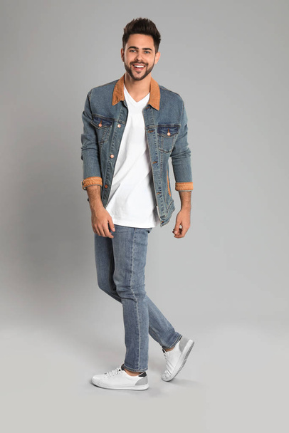 Young man in stylish jeans on grey background - Φωτογραφία, εικόνα