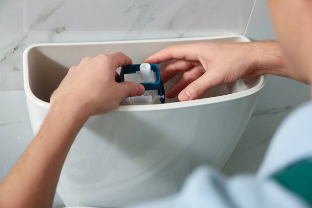 Professional plumber repairing toilet in bathroom, closeup - Foto, afbeelding