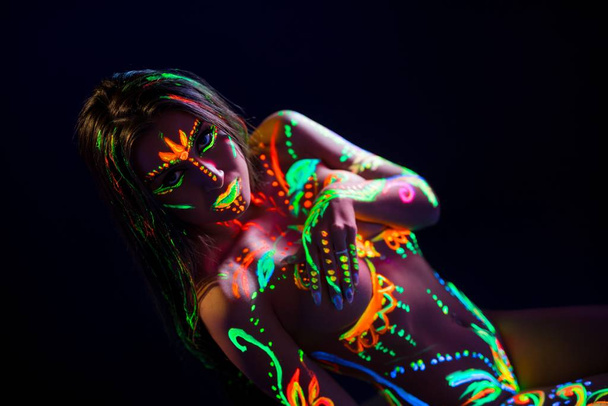 Girl with UV color pattern bodyart in the dark - Foto, immagini