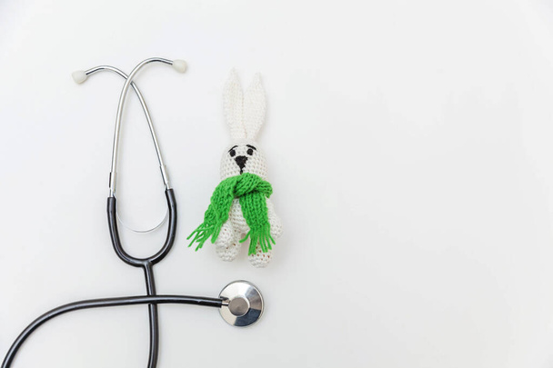 Simply minimal design toy bunny and medicine equipment stethoscope isolated on white background. Health care children doctor concept. Pediatrician symbol. Flat lay, top view copy space - Photo, Image