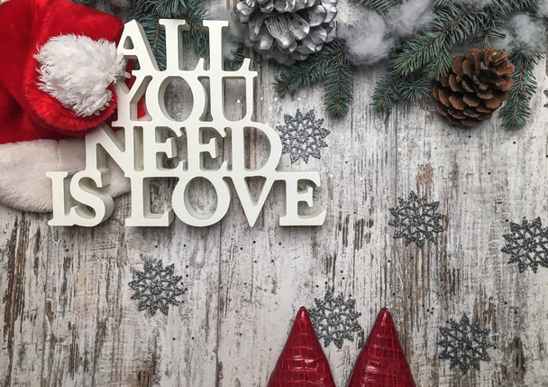 Zapatos rojos en piso de madera aplanado con símbolos de Navidad y sombrero de Santa
.  - Foto, Imagen