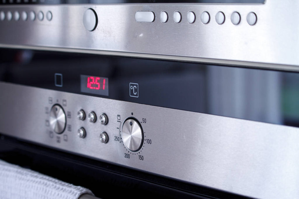 Close-up the front panel of the oven with control poles and switching baking modes, selective focus - 写真・画像