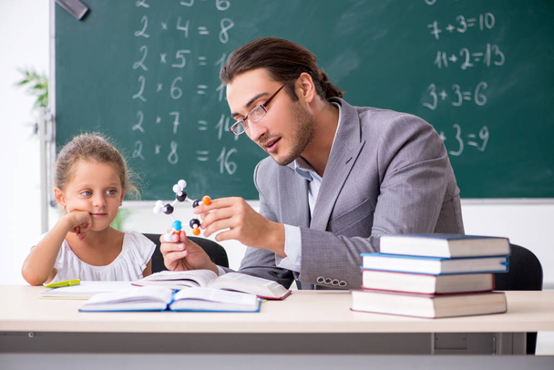 Teacher with young girl in the classroom - Photo, Image