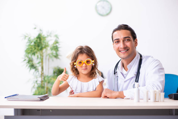 Młody lekarz pediatra z małą dziewczynką - Zdjęcie, obraz