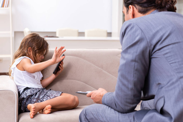 Дитячий психолог відвідує маленьку дівчинку
 - Фото, зображення