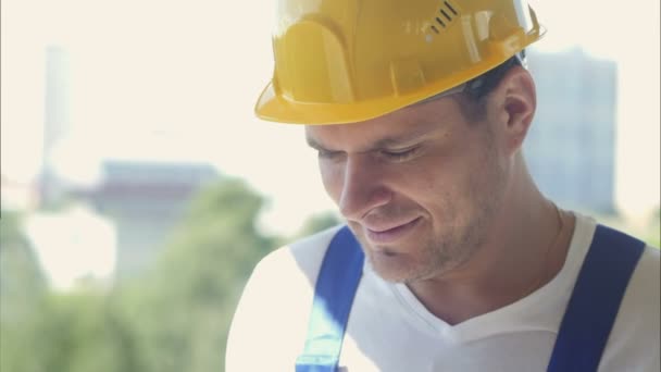 Smiling construction worker smiling and standing on building site - Felvétel, videó