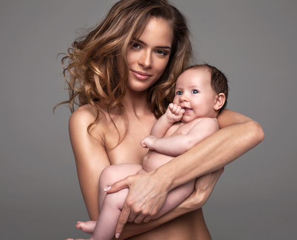 Beautiful baby with mother posing in studio - Foto, afbeelding