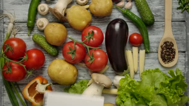 Hand wirft Notizblock für Rezepte auf den Tisch mit Gemüse - Filmmaterial, Video