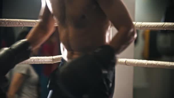 Trening bokserski - zmęczony spocony człowiek z ochraniaczem na zęby siedzi na rogu ringu na krześle - Materiał filmowy, wideo