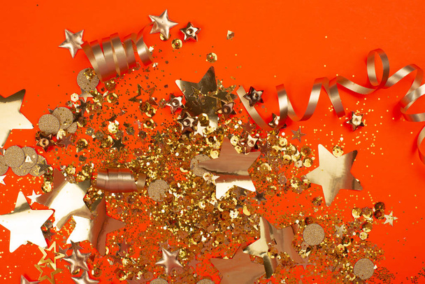Golden sparkles on orange background. - Foto, Imagen