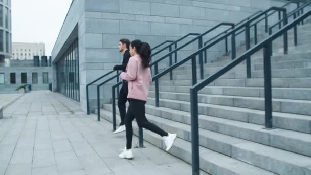 Fitness pár běží dolů po schodech ven. Sport pár trénink běh cvičení - Záběry, video