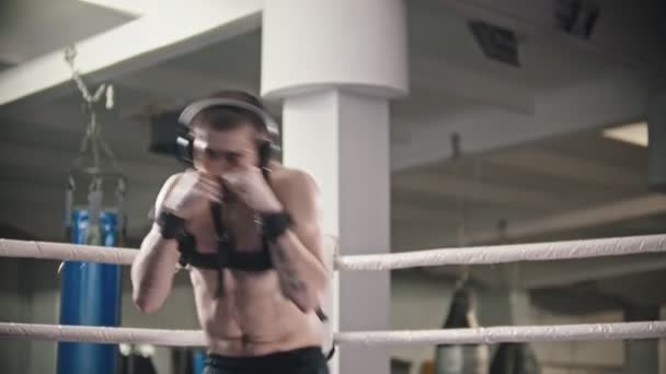 ボックストレーニング-ヘッドフォンを身に着けている男のトレーニング-拘束包帯を身に着けている影の戦い - 映像、動画