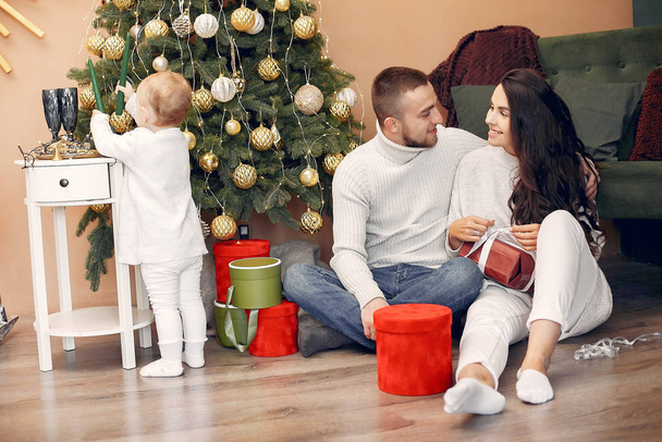 Family sitting at home near christmas tree - Foto, imagen