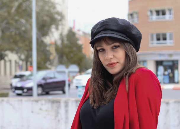 Krásná mladá žena s červenou bundou a koženou čepicí - Fotografie, Obrázek