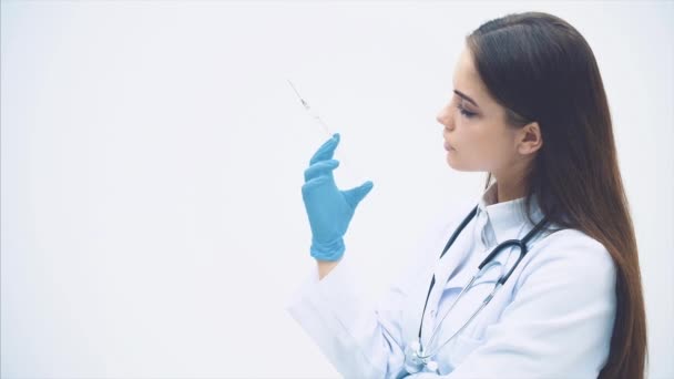 Professional female doctor in mask and gloves preparing disposable one-off syringe with transparent drug. Woman physician at work. - Footage, Video