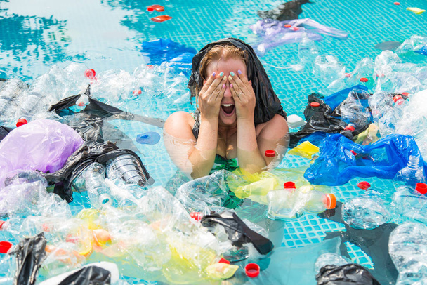 Ecologie, plastic afval, milieu noodsituatie en watervervuiling - Schreeuwende vrouw met een plastic zak over zijn hoofd in een vies zwembad - Foto, afbeelding