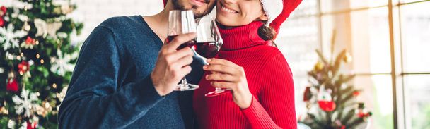 Ρομαντικό γλυκό ζευγάρι σε santa καπέλα διασκεδάζοντας και πίνοντας κρασί - Φωτογραφία, εικόνα
