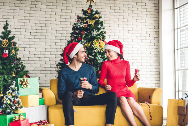 Porträt eines glücklichen süßen Paares mit Weihnachtsmannhüten, das Spaß beim Lächeln hat  - Foto, Bild