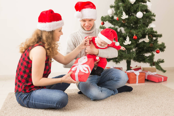 休日、子供と家族のコンセプト-自宅で一緒にクリスマスを祝う赤ちゃんを持つ幸せなカップル. - 写真・画像