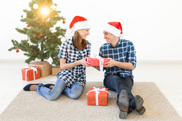 Holidays, christmas and family concept - Happy couple opening gifts at home. - Фото, зображення