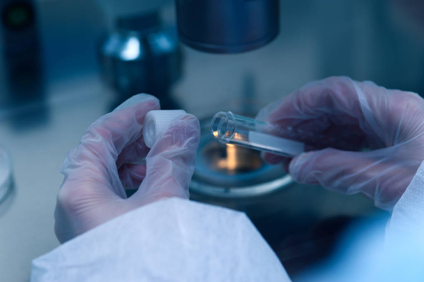 Closeup of microbiologists hand opening test tube - Zdjęcie, obraz