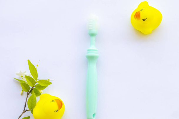 spazzolino da denti del bambino 6 mesi di assistenza sanitaria cavità orale del bambino con disposizione giocattolo dell'anatra piatto lay style su sfondo bianco
  - Foto, immagini