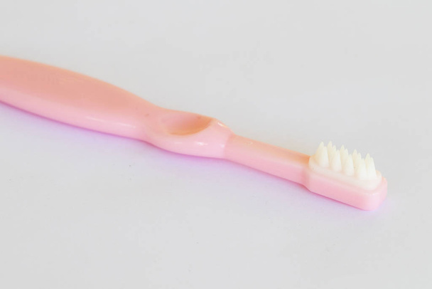 cepillo de dientes de bebé de 8 meses de edad cuidado de la salud cavidad oral de disposición de bebé estilo de puesta plana sobre fondo blanco
  - Foto, Imagen