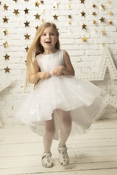 Vertical joyful little girl in an elegant dress. Funny child. - Фото, зображення