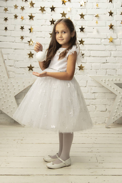 Verticaal elegant kind in een witte jurk. Klein meisje model - Foto, afbeelding