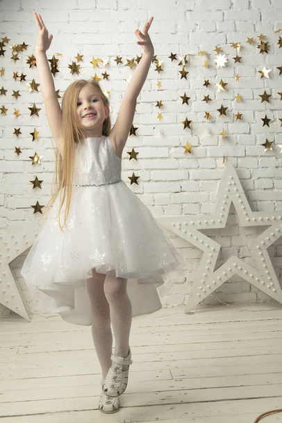Вертикальная радостная маленькая девочка в элегантном платье. Смешной ребенок
. - Фото, изображение