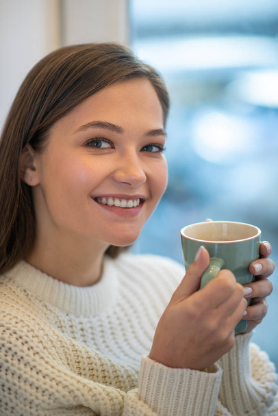 Delighted young woman enjoying her delicious coffee - Φωτογραφία, εικόνα