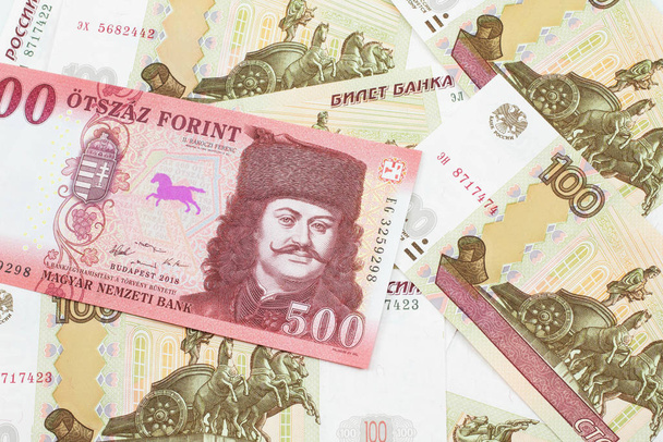 Kırmızı bir Macar beşyüz kırk banknotunun yakın plan resmi. Arka planda Rusça yüz ruble banknot var. - Fotoğraf, Görsel