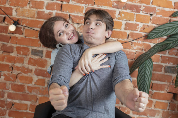 Funny couple fooling around on brick wall background - Foto, imagen