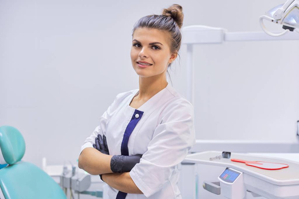 Portrait of young confident smiling dentist doctor woman, female with arms crossed - Foto, Bild